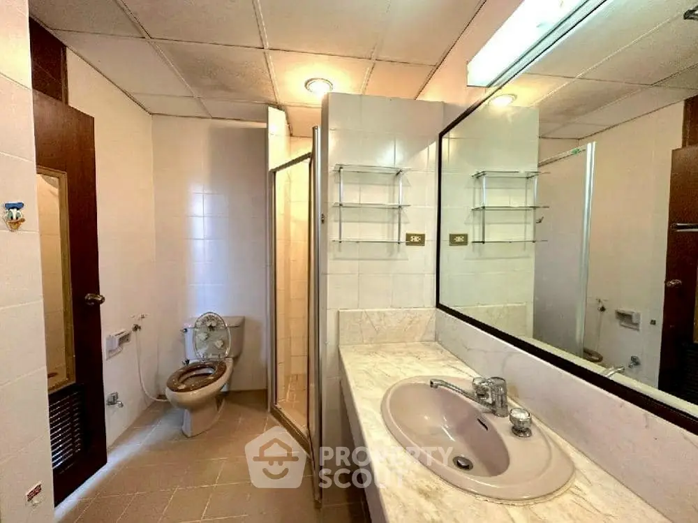 Spacious bathroom with modern fixtures and large mirror