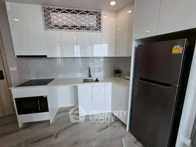 Modern kitchen with sleek white cabinets and stainless steel appliances