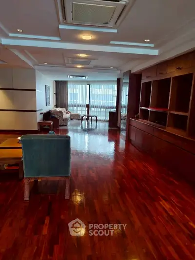 Spacious living room with polished wooden floors and elegant furnishings.