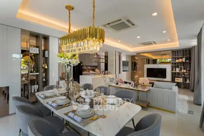 Luxurious open-plan living and dining area with elegant decor and modern lighting.