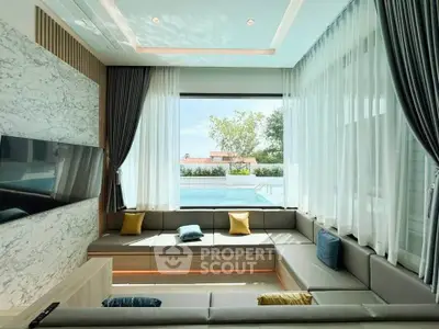 Luxurious living room with pool view, modern decor, and elegant seating arrangement.