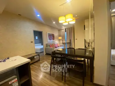 Modern living room with elegant dining area and cozy seating, featuring warm lighting and stylish decor.