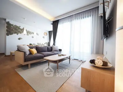 Modern living room with stylish decor and natural light, featuring a cozy sofa and elegant wooden furniture.