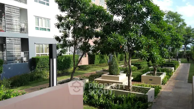 Modern apartment building with lush landscaped garden and trees