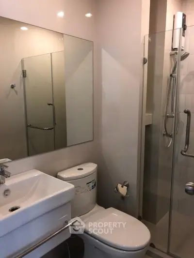 Modern bathroom with glass shower and sleek fixtures in a contemporary apartment.