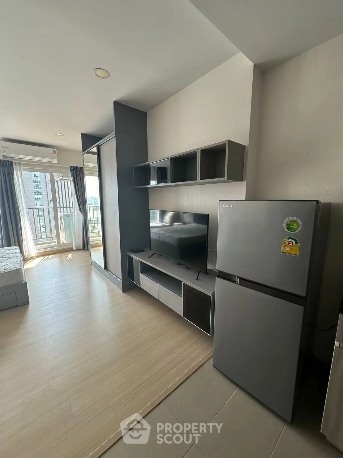 Modern studio apartment with sleek furniture and balcony view