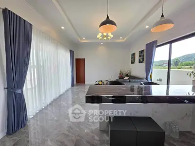 Spacious modern living room with marble flooring and large windows offering scenic views.