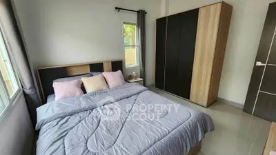 Cozy bedroom with modern wardrobe and large window for natural light.