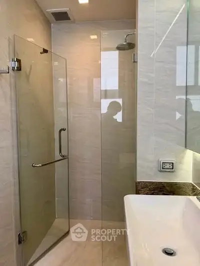 Modern bathroom with glass shower enclosure and sleek sink design