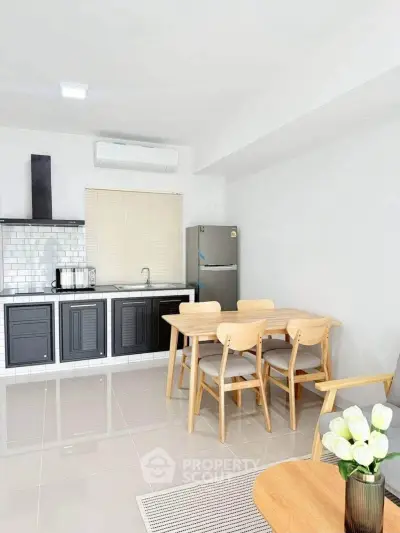 Modern kitchen with dining area featuring sleek cabinets and stainless steel appliances.