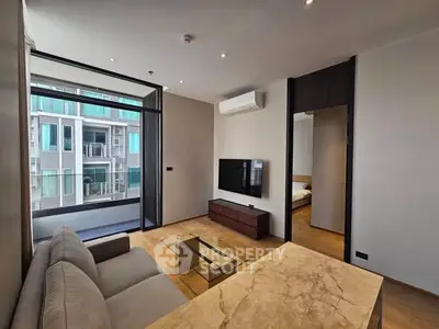 Modern living room with sleek furniture and large windows offering a view of the building exterior.