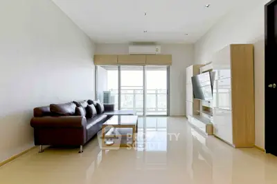 Spacious modern living room with sleek furniture and large windows offering natural light.