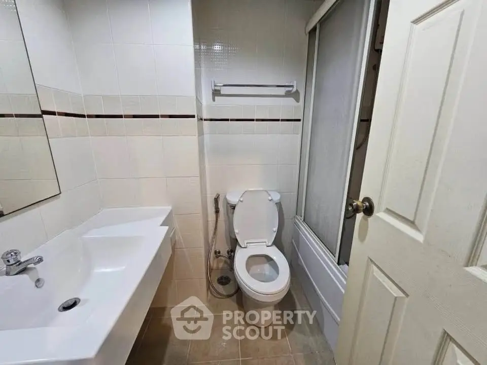 Compact bathroom with modern fixtures and a bathtub in a cozy real estate unit.