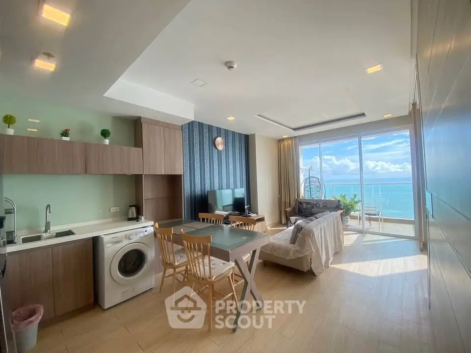 Stunning open-layout living room with ocean view, modern kitchen, and cozy dining area.