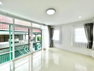 Spacious living room with pool view and large windows in modern home