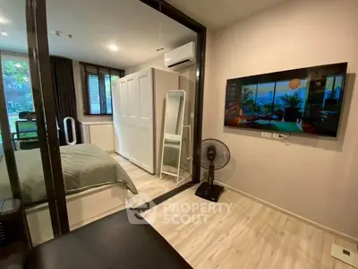 Modern bedroom with glass partition, air conditioning, and stylish decor in a cozy apartment.