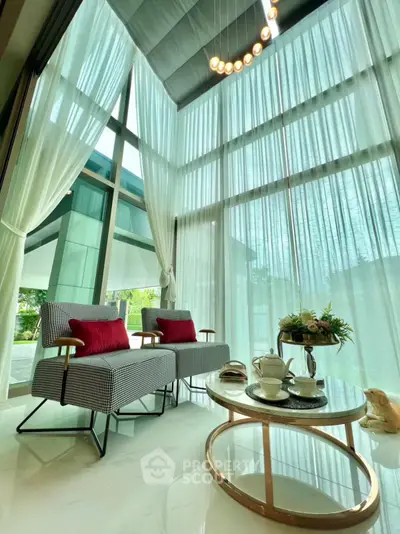 Luxurious living room with high ceilings, elegant decor, and large windows offering stunning natural light.