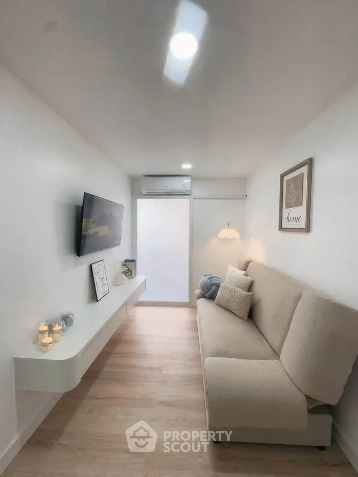 Modern minimalist living room with sleek design and cozy ambiance, featuring a wall-mounted TV and stylish decor.