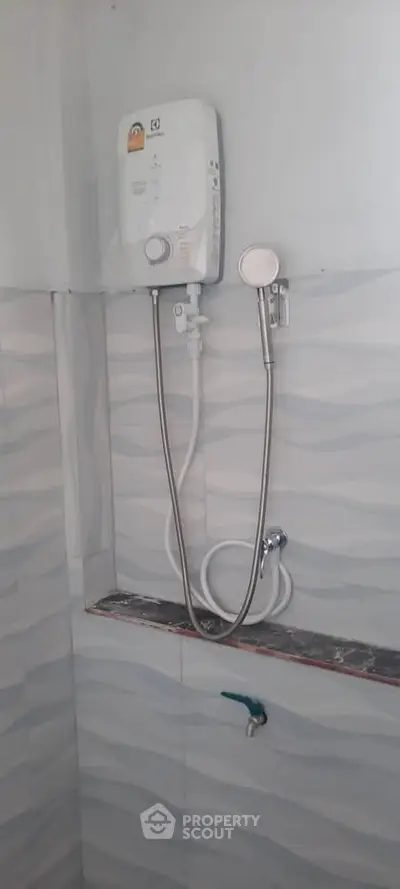 Compact bathroom with modern water heater and shower setup