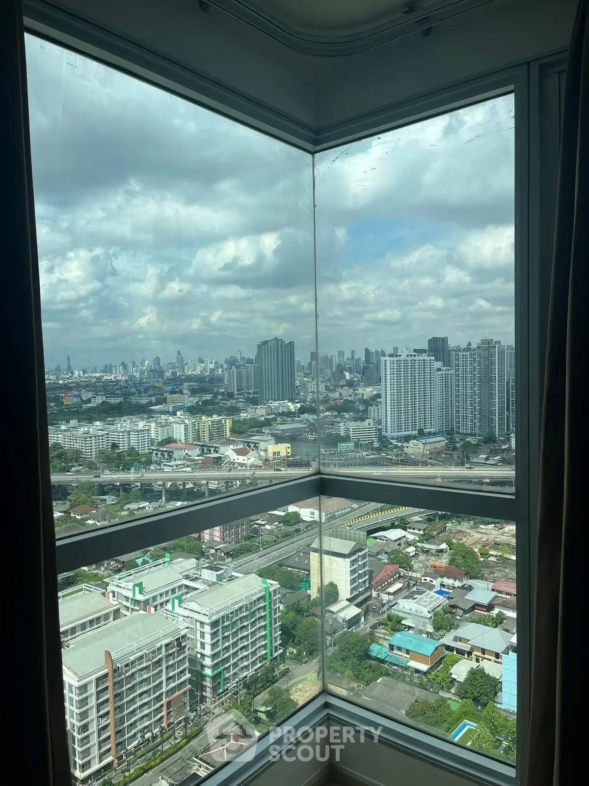 Stunning cityscape view from high-rise corner unit window.