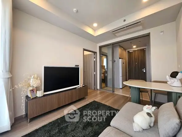 Modern living room with stylish decor and open layout, featuring a cozy sofa and sleek TV unit.