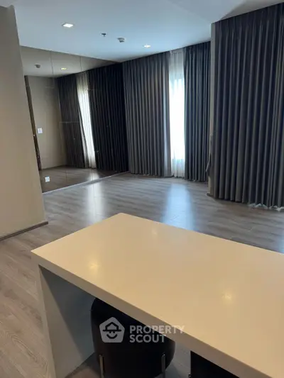 Spacious modern living room with elegant flooring and large windows.