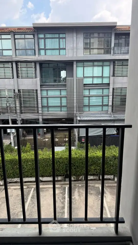 Modern urban building view from balcony with parking area and greenery
