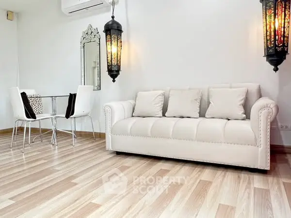 Chic living room with elegant white sofa and stylish dining area.