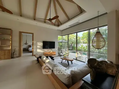 Spacious living room with modern decor and garden view, featuring high ceilings and natural light.