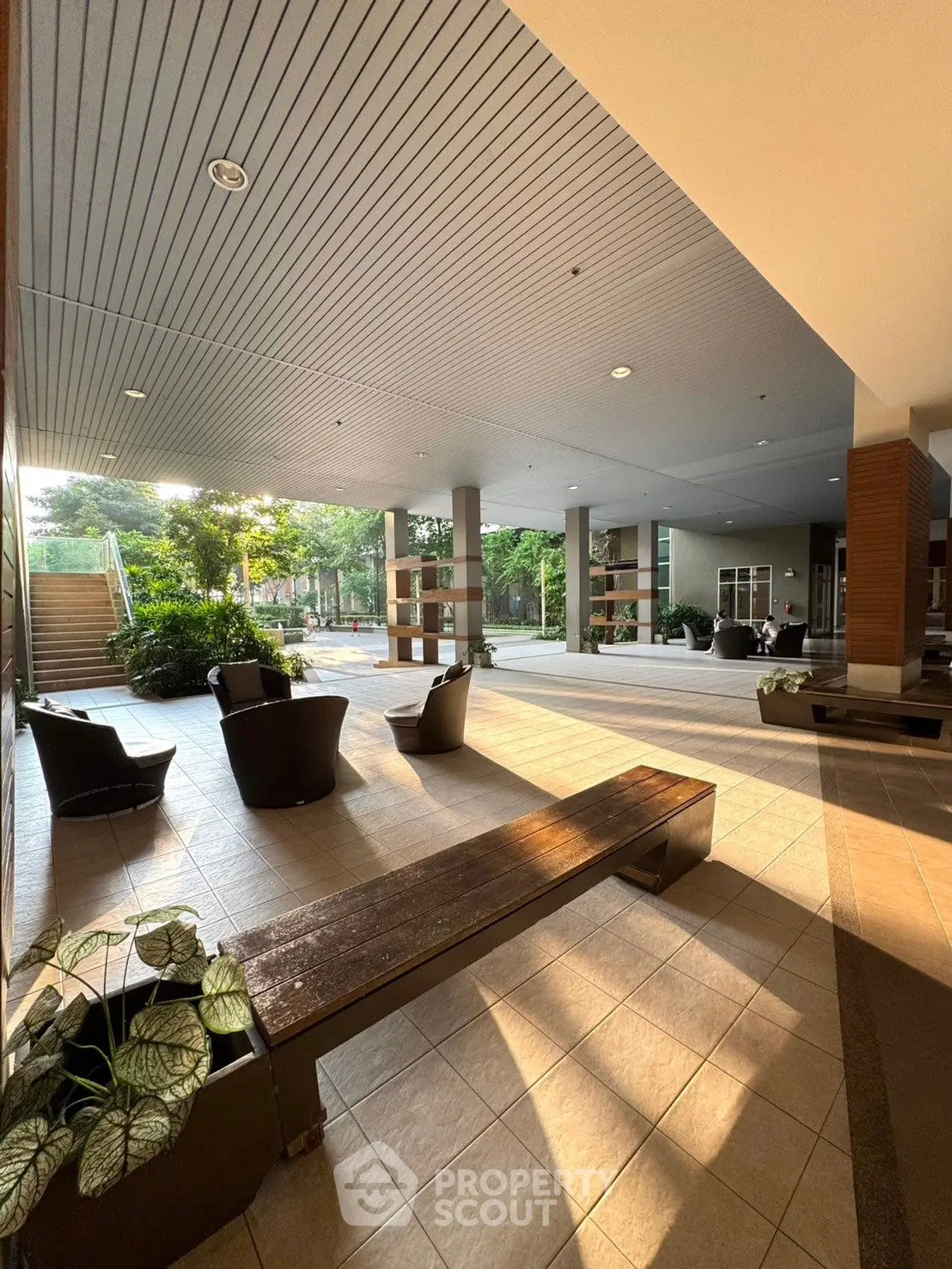 Spacious modern building entrance with stylish seating and lush greenery