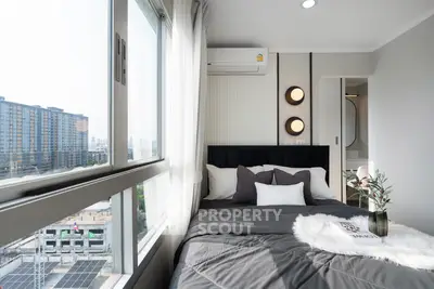 Modern bedroom with city view, featuring stylish decor and large windows for natural light.