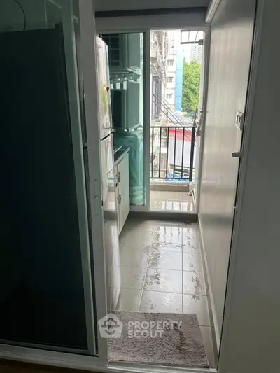 Compact balcony with glass doors and city view, ideal for urban living.