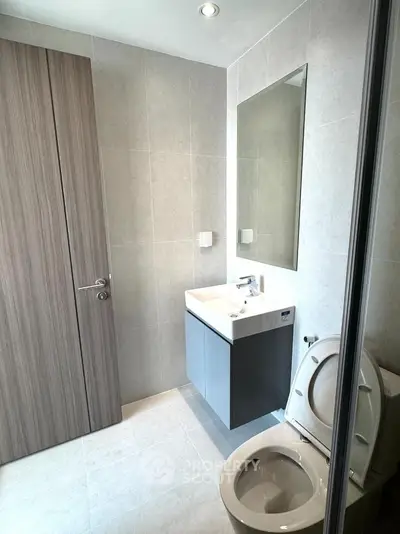 Modern bathroom with sleek fixtures and neutral tones, featuring a stylish vanity and mirror.