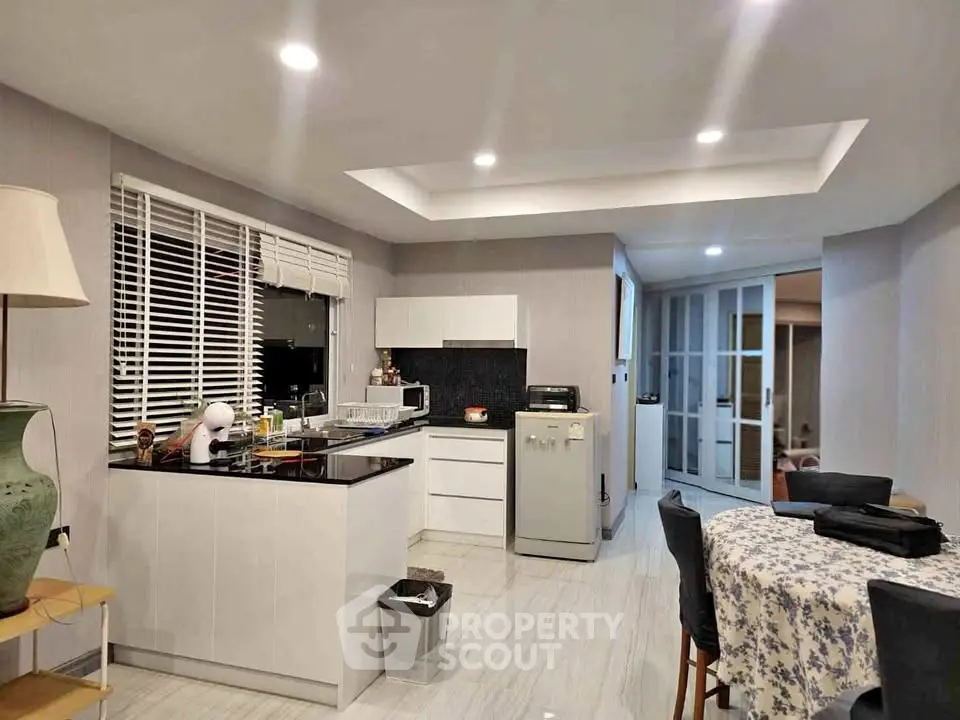 Modern kitchen with sleek white cabinets and dining area in open layout