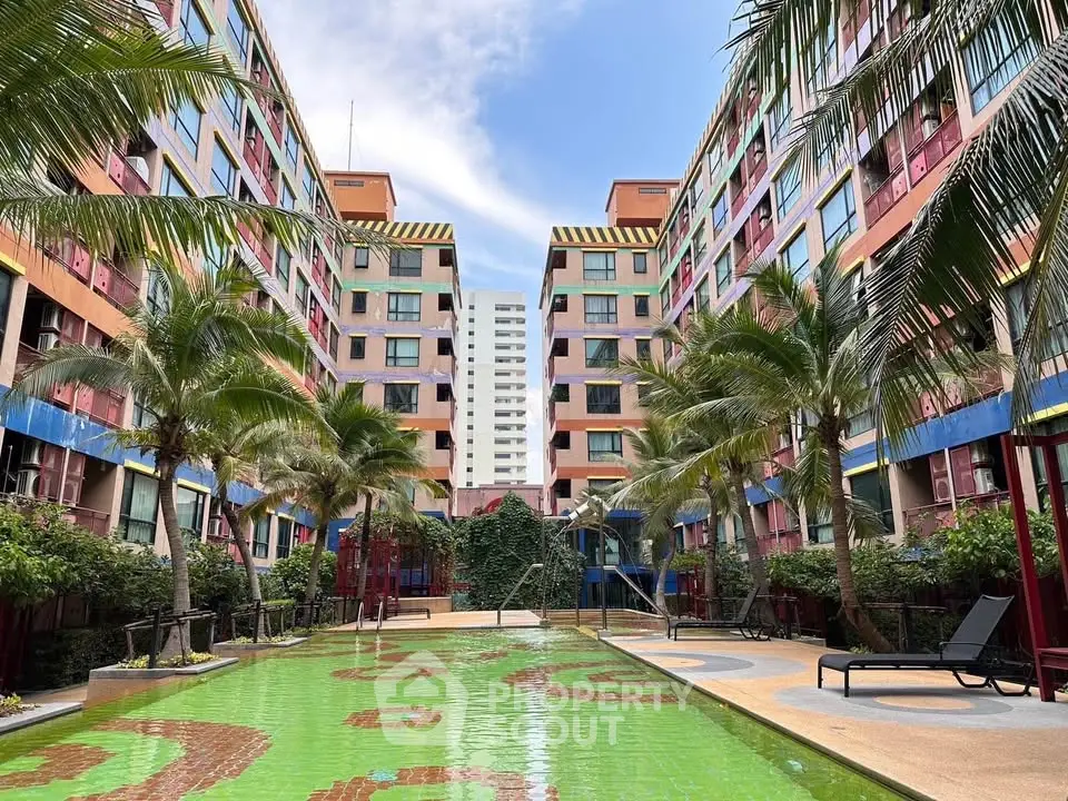 Vibrant apartment complex with lush poolside and palm trees, perfect for urban living.