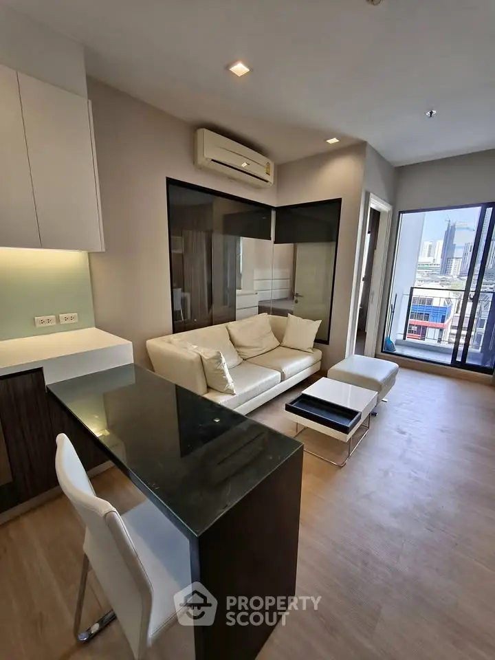 Modern living room with city view, featuring sleek furniture and large windows for natural light.