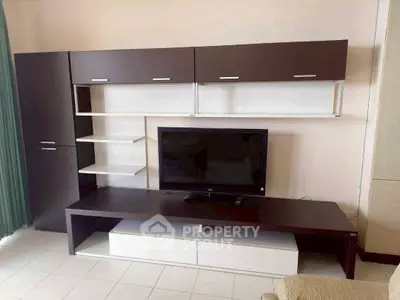 Modern living room with sleek entertainment unit and flat-screen TV, perfect for contemporary living.