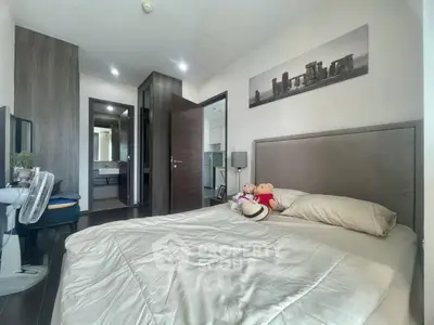Cozy bedroom with modern decor and ensuite bathroom in a stylish apartment.