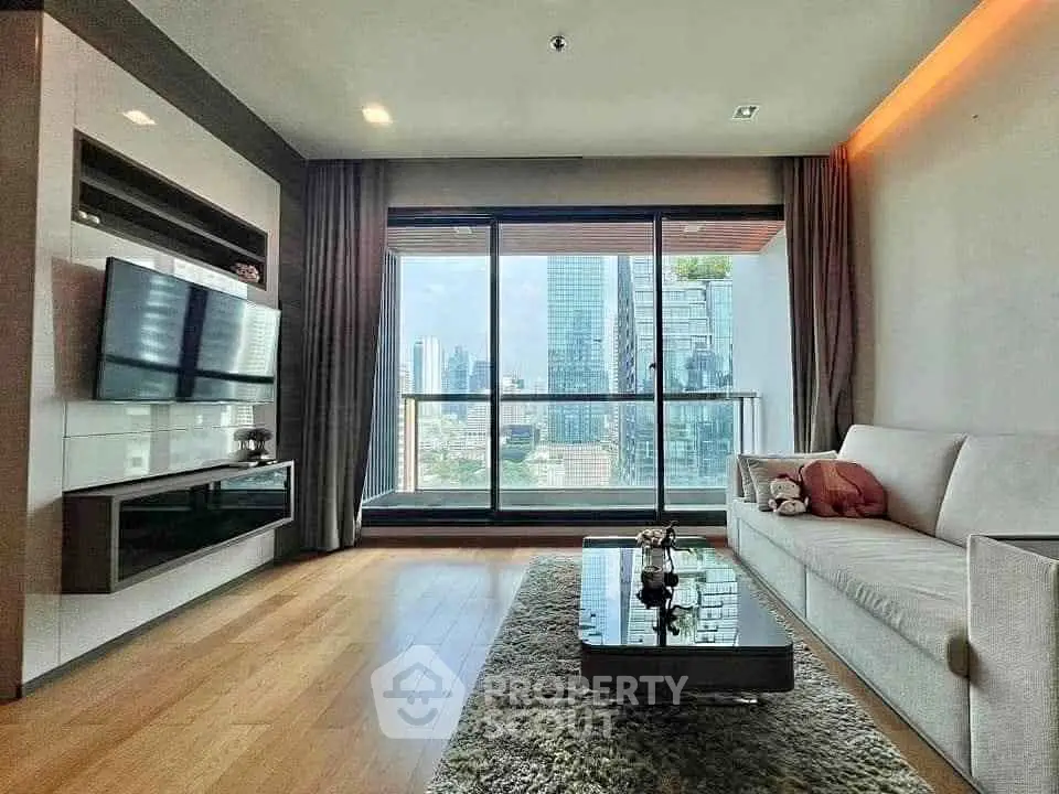 Modern living room with city view, sleek furniture, and large windows for natural light.