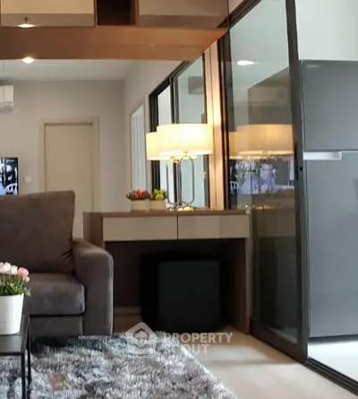 Modern living room with plush sofa, stylish decor, and glass sliding doors leading to a balcony.