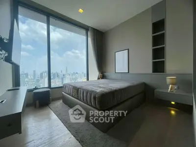 Luxurious bedroom with stunning city view and modern decor in high-rise apartment.