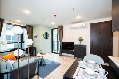 Modern living room with stylish decor and natural light, featuring a cozy seating area and dining space.