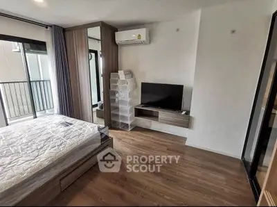 Modern bedroom with wooden flooring, large window, and sleek furniture in a stylish apartment.