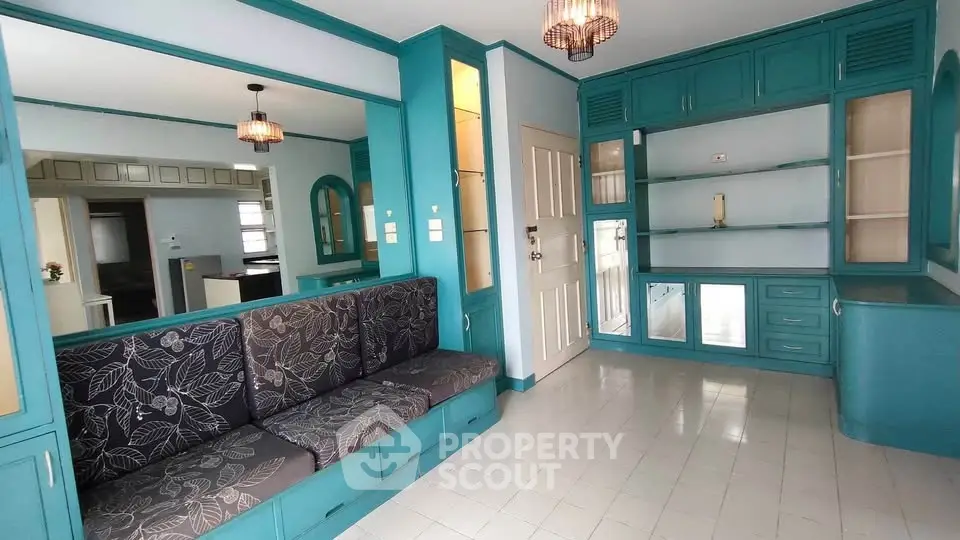 Charming living room with built-in teal cabinetry and cozy seating area.