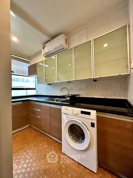 Modern kitchen with sleek cabinets and built-in washing machine