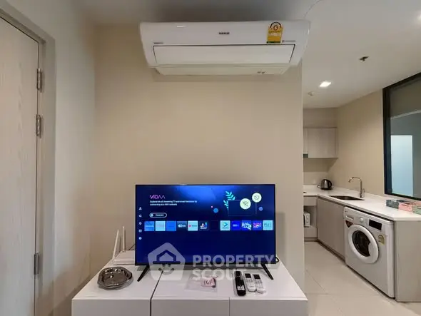 Modern apartment interior with TV, air conditioner, and kitchen appliances