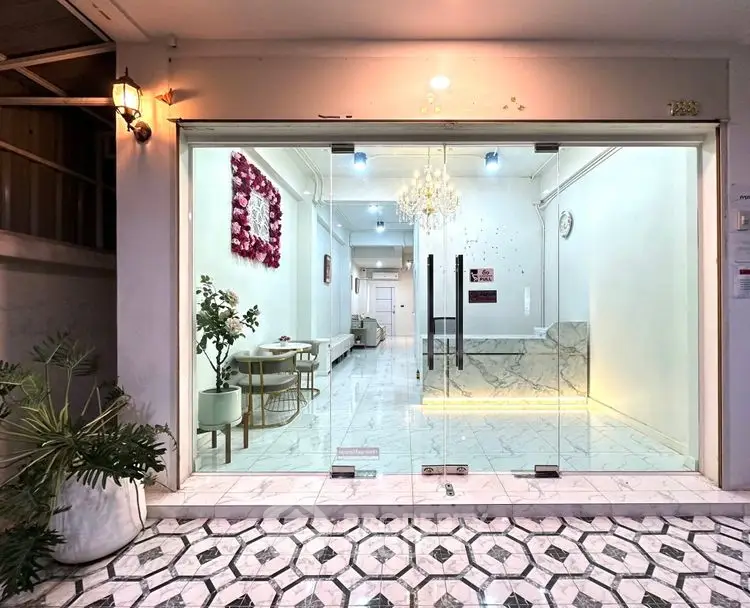 Elegant entrance with glass doors, marble flooring, and modern decor