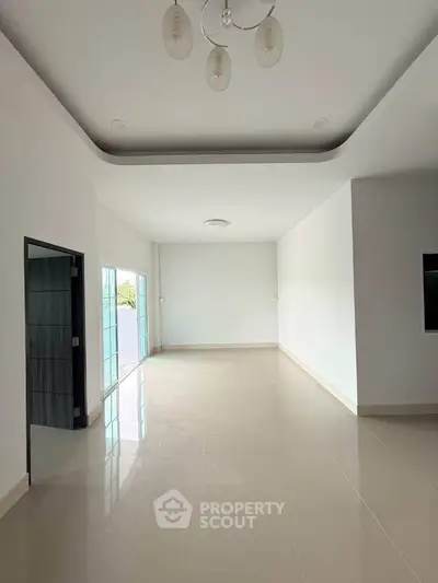 Spacious modern living room with elegant ceiling design and large windows for natural light.