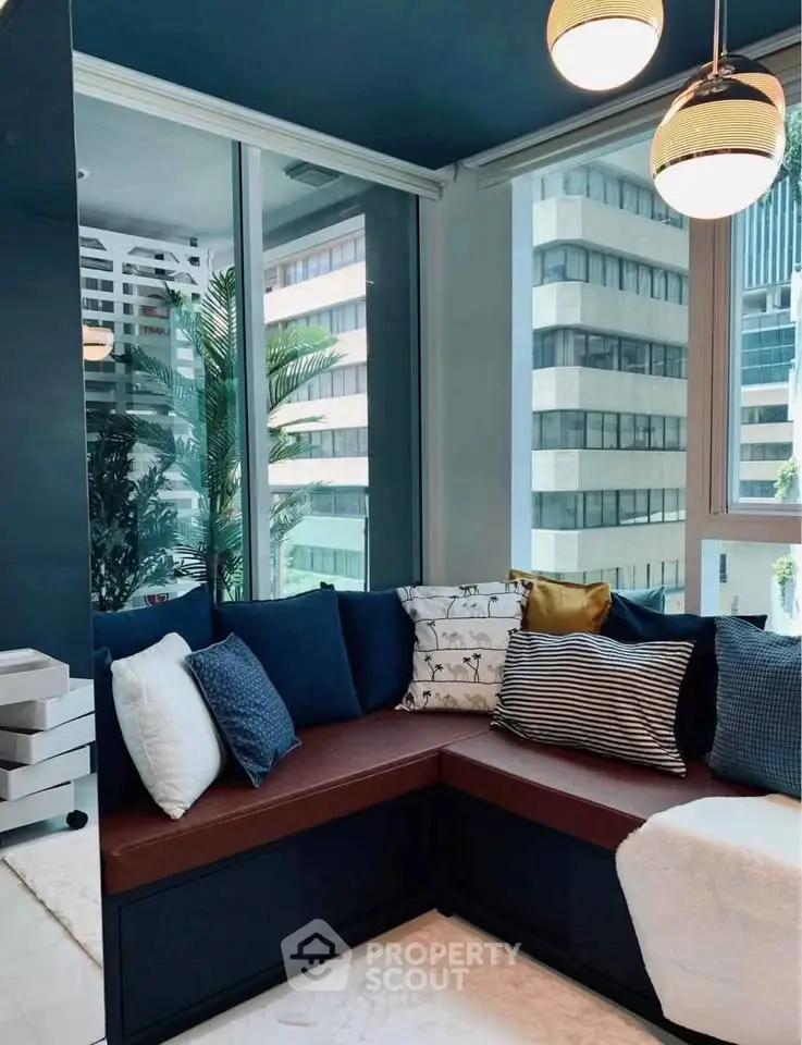 Modern living room with stylish corner seating and large windows offering city views.