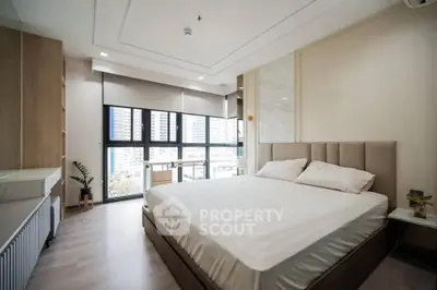 Spacious modern bedroom with large windows and city view, featuring elegant decor and ample natural light.